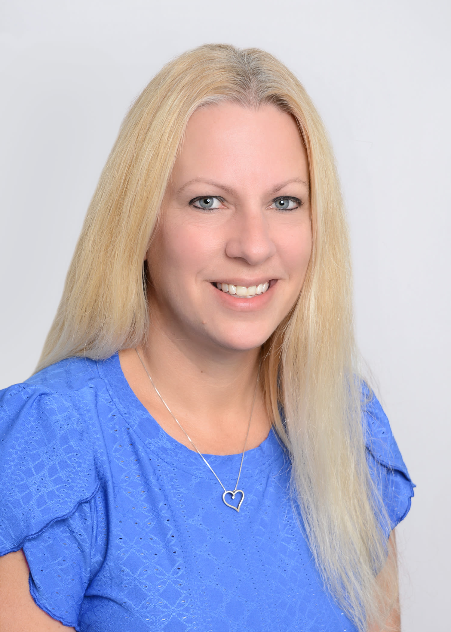 Smiling blonde woman in blue top portrait