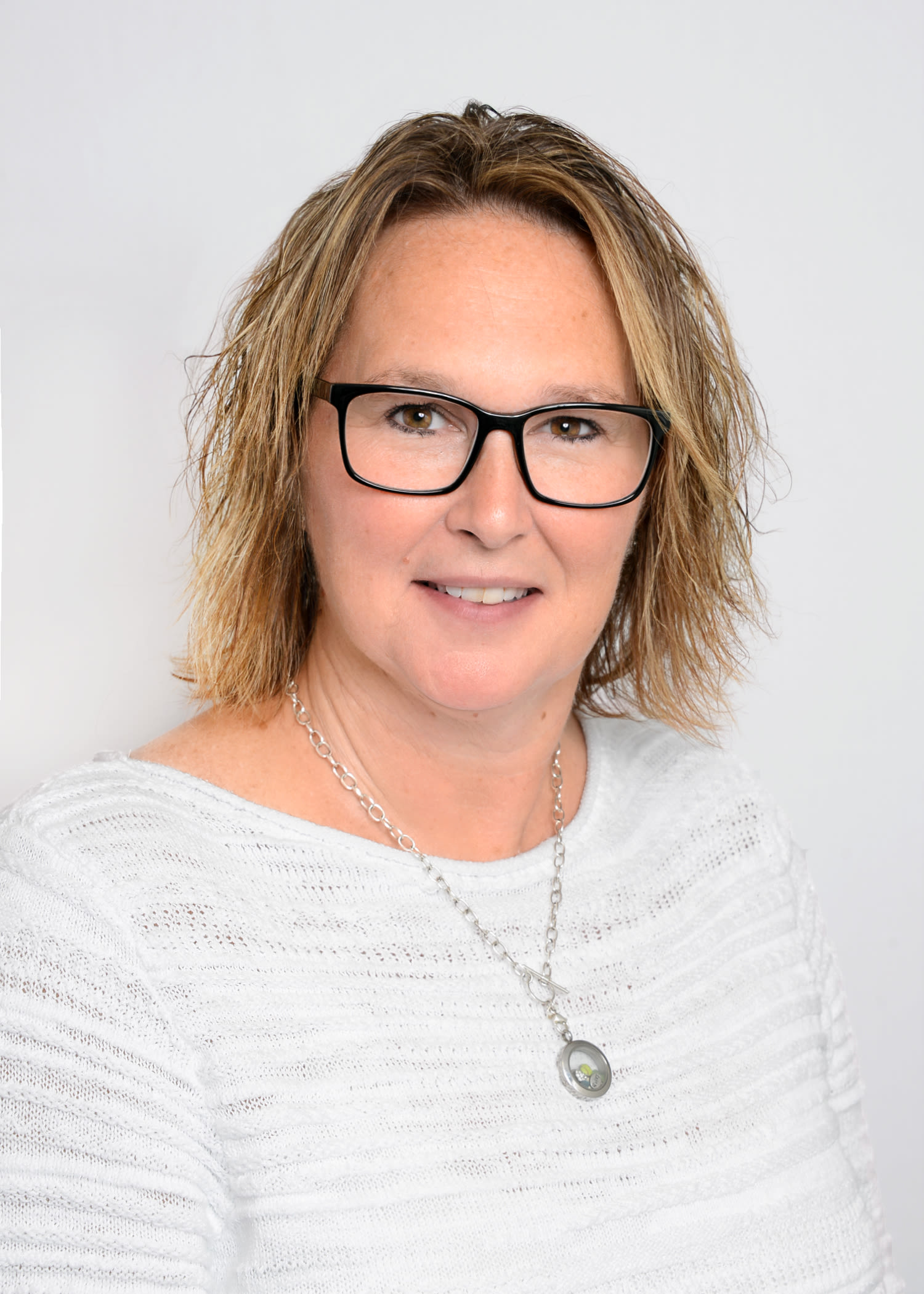 Woman with glasses smiling in professional headshot