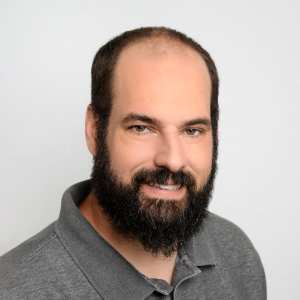 Bearded man in gray polo shirt headshot