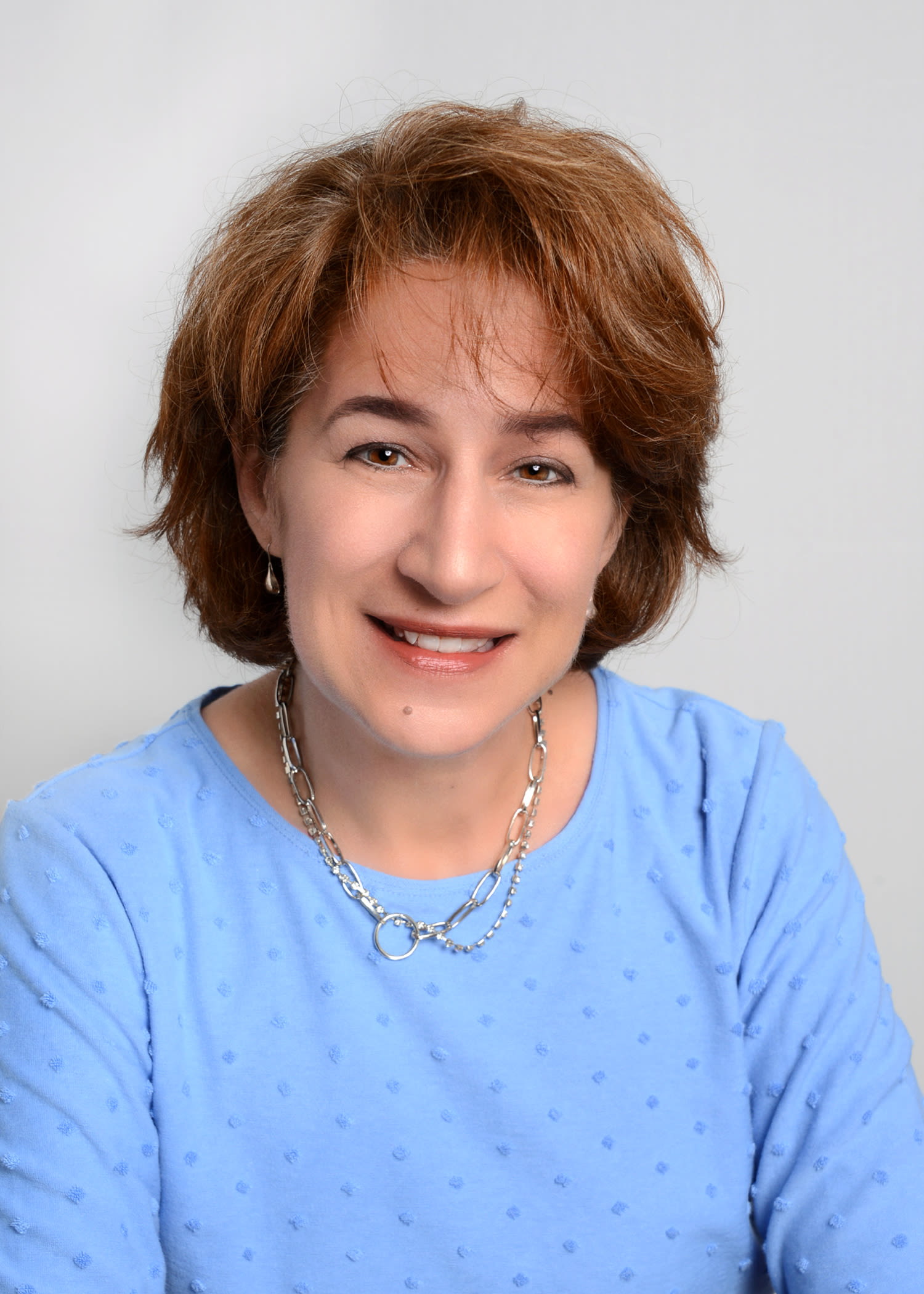Smiling woman in blue blouse studio portrait