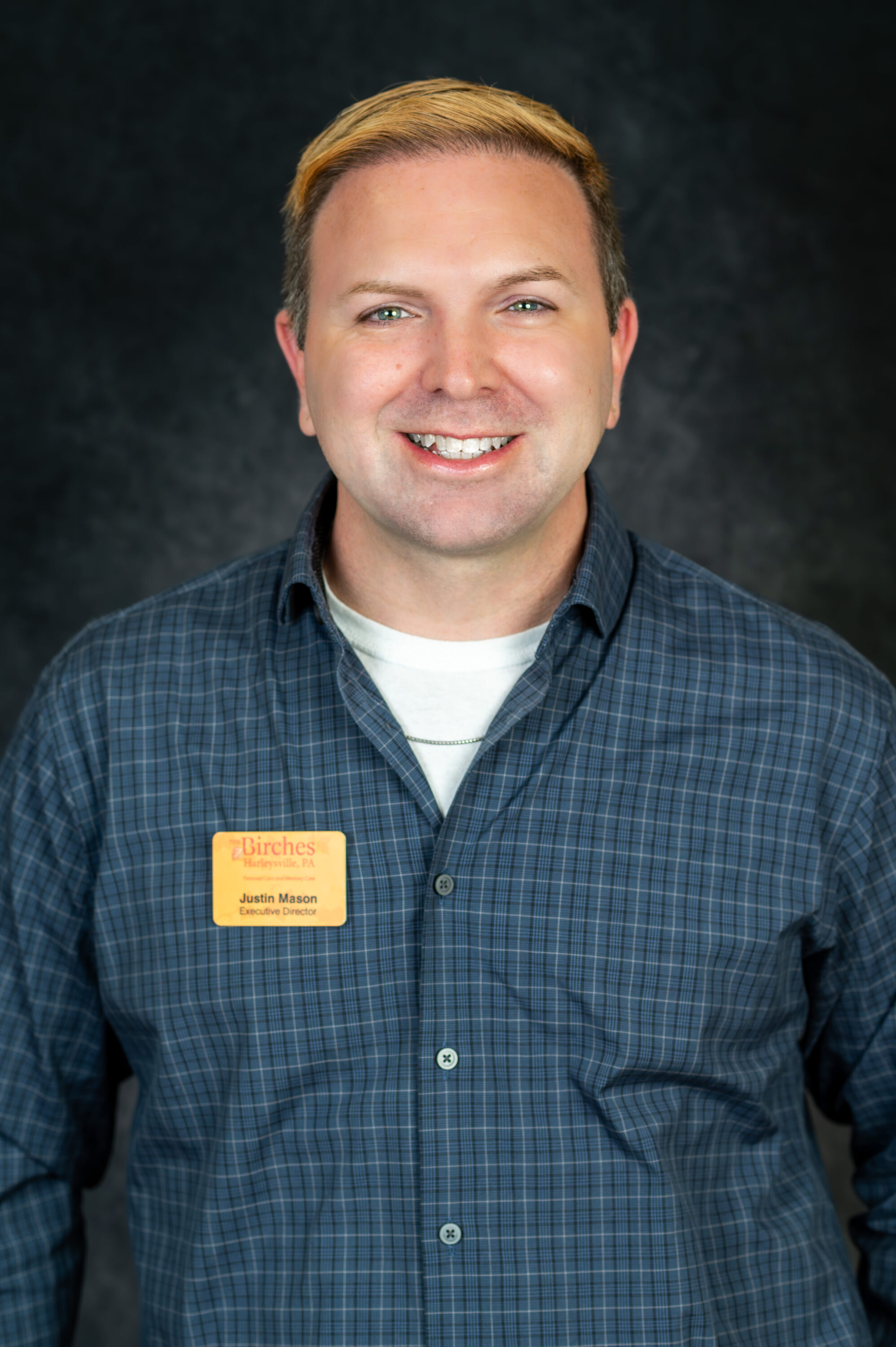 Smiling executive director wearing name badge indoors