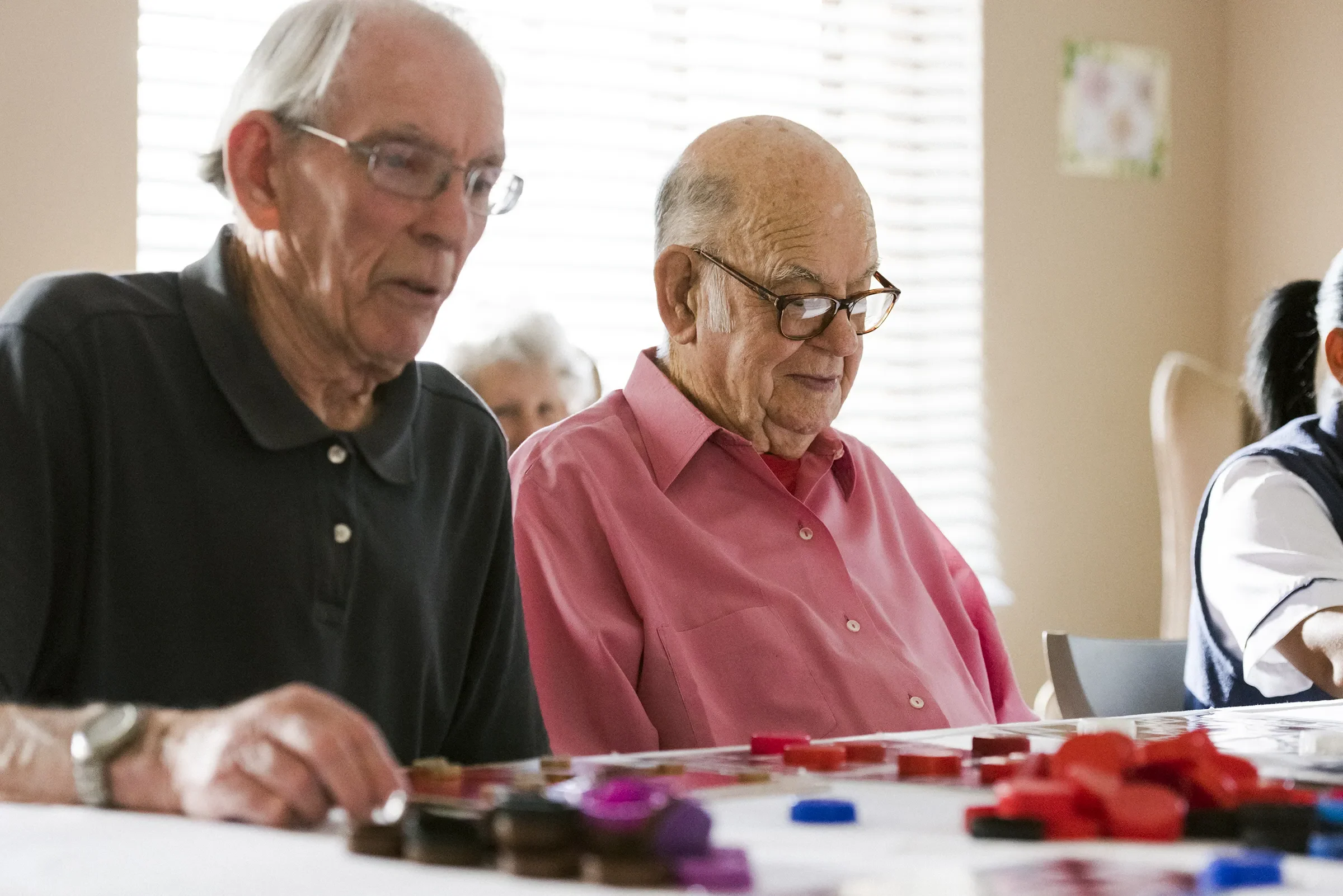 Elderly men playing board game at table